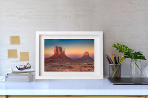 A broad foreground butte contrasts with a smaller distant Mitten