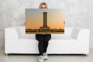 Symmetrical view of the Beijing monument against a pale orange sky