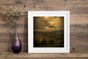 Tuscan hills and vineyards beneath dramatic dark clouds