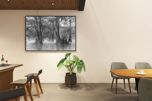 Modern dining room with a wooden table, chairs, and a large framed picture on the wall.