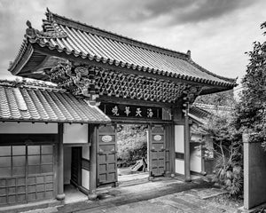 Buddhist temple entrance with tiled roof and carved wood details