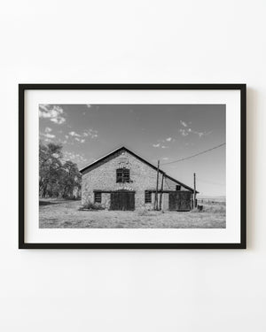 Nebraska stone barn facade with weathered wooden doors in black and white