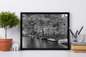 Amsterdam residential canal scene with boats and railing in monochrome