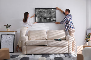 Historic Amsterdam canal houses with moored boats in black and white