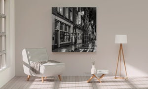 Wet cobblestone street reflecting lights in Amsterdam