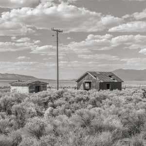 Weathered wooden sheds at Currie Nevada beneath a cloud-filled sky