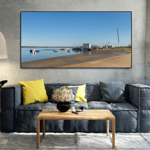 Clear sky above a quiet fishing pier and exposed harbour shore