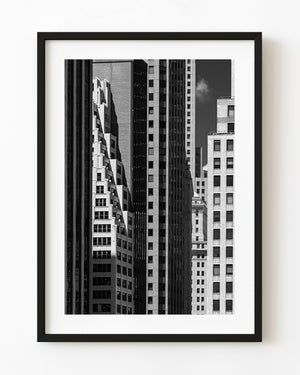 Black and white photograph of layered Manhattan buildings with repeating windows and deep shadows.