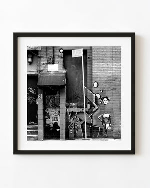 New York City graffiti and pasted street art on a brick wall in black and white