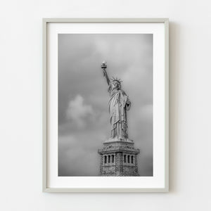 Dramatic black and white image of the Statue of Liberty with cloud backdrop