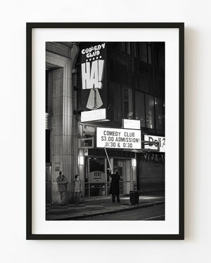 Worker updating signboard at NYC comedy club entrance
