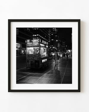 Illuminated food cart on a New York street at night in black and white