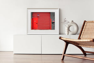 Red metal door and horizontal shutter contrasting with grey bricks