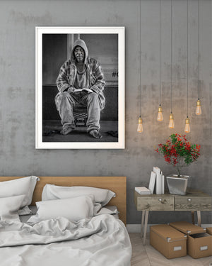 Black and white portrait of a man in a hooded sweatshirt with a book