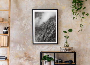 Rugged alpine rock face emerging from pale mountain mist