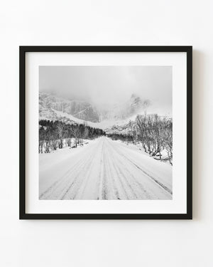 Snowy road to Norwegian peaks black and white