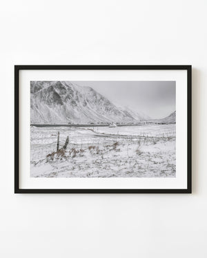 Norwegian winter landscape with a wire fence and snowy mountains