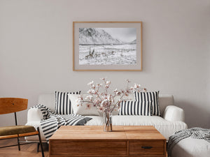 Small white house beneath snow-streaked Norwegian mountains