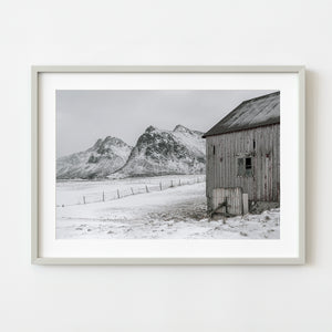 Snow-covered mountains behind old barn in Norway