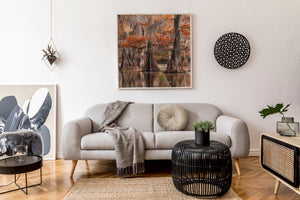 Salón moderno con un sofá gris, cojines decorativos y un cuadro mural.