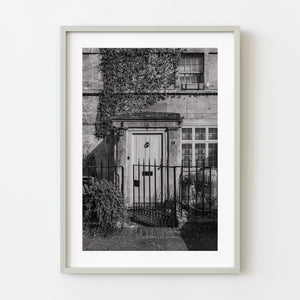 Old English front door framed by wrought-iron gate