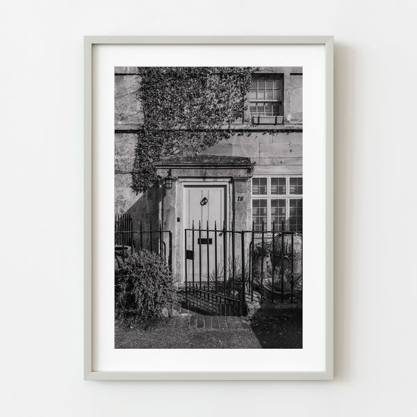 Old English front door framed by wrought-iron gate