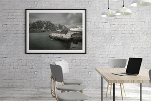 Lofoten mountain backdrop behind a faded white waterfront hotel