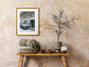 Cuban wall scene with blue Pontiac and wrought iron gate
