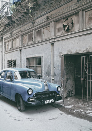 Vintage American car in front of old Cuban garage