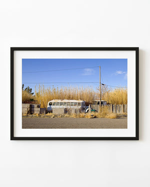 Old school bus behind a weathered wooden fence in California