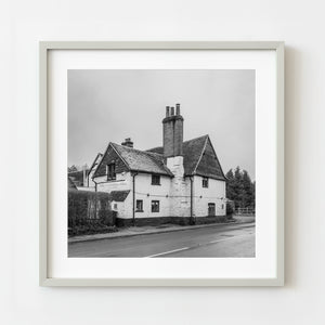 Framed black and white photograph of a traditional building on a street.