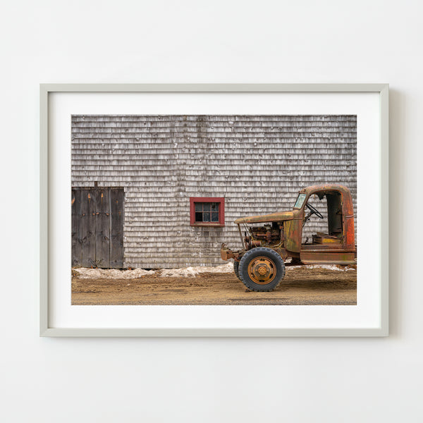 Old rusted truck against wooden barn wall