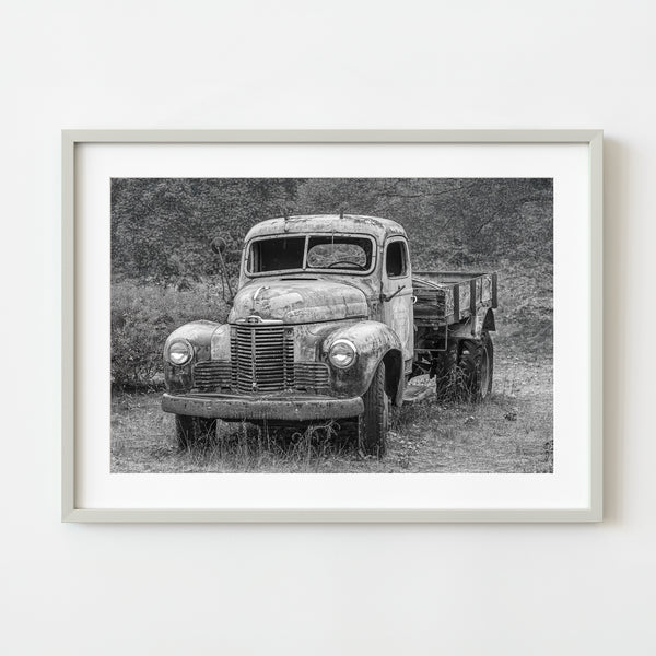 Abandoned vintage truck with cracked windshield in black and white