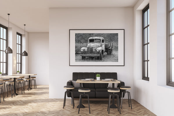 Black-and-white wall art of abandoned truck in natural setting