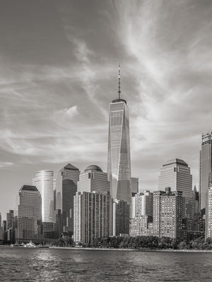 Lower Manhattan skyline beneath wispy clouds in black and white