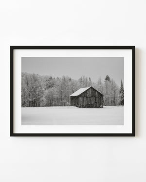 Black and white photograph of rural Ontario barn during heavy snowfall
