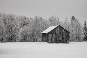 Snow covered wooden barn in open winter field Ontario Canada