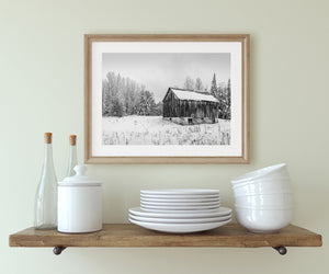 old farm barn surrounded by snow in black and white