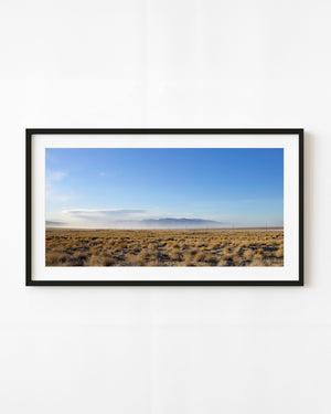 Open California plain with golden grasses beneath a blue sky and distant mountains