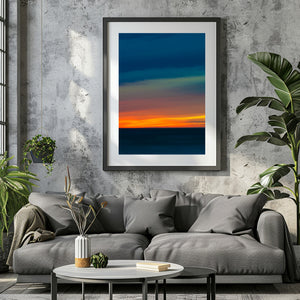 Orange light streaking across a deep blue seascape at sunset