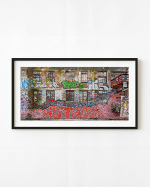Colorful graffiti covering weathered brick wall with windows in Oslo