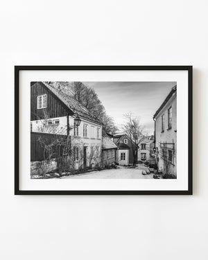 Snowy lane between gabled houses in Oslo, black and white winter photograph