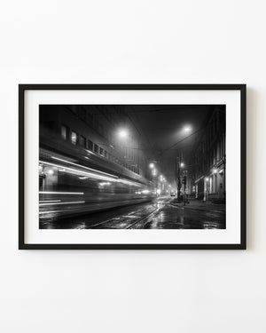 Moving Oslo tram on a rainy street at night, black and white photograph