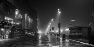 Foggy Aker Brygge promenade with cafes and waterfront lights