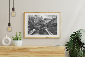 Graffiti-covered buildings beside the Oslo river in monochrome