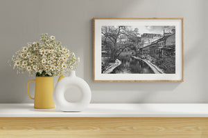 Black and white Oslo river photograph with graffiti, bare trees and snow