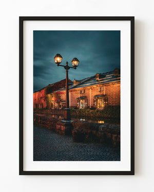 Otaru canal warehouses at night with glowing streetlamp