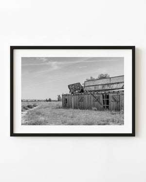 Weathered Outer Limits restaurant in Nebraska beside open grassland, black and white