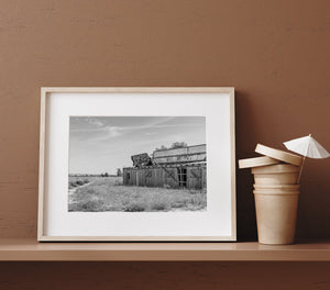 Empty Nebraska restaurant beneath a broad sky with distant railway cars