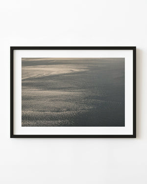 Sunlight shimmering across the Pacific Ocean in an abstract aerial photograph